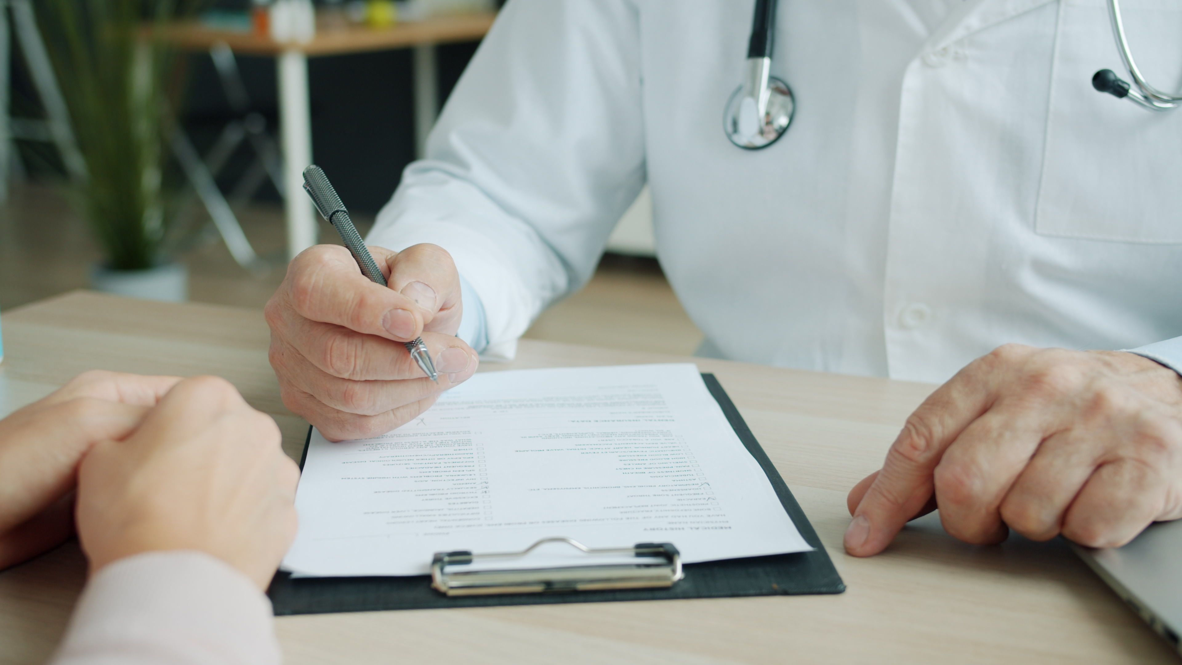 Arzt bespricht mit einem Patienten ein Dokument während einer Untersuchung
